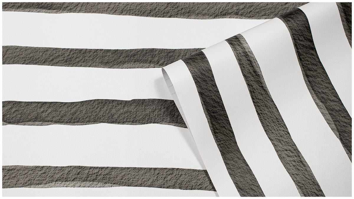 Roll of black white watercolor striped self-adhesive wallpaper, close up texture shot, peel and stick wall covering sample display